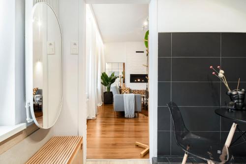 een hal met een spiegel en een kamer met een tafel bij House Of Malgosia in Gdańsk