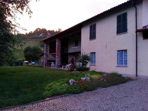 a large white house with a garden in front of it at B&B Bricco Fiore in Briaglia
