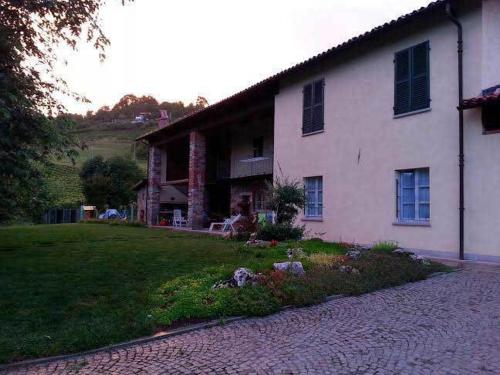 une grande maison blanche avec un jardin en face de celle-ci dans l'établissement B&B Bricco Fiore, à Briaglia