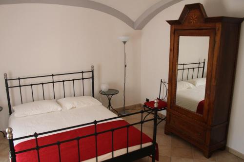 - une chambre avec un lit et un miroir dans l'établissement B&B Bricco Fiore, à Briaglia