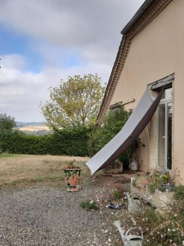 un grand objet blanc se penchant contre le côté d'une maison dans l'établissement Chez Régis, à Lachapelle