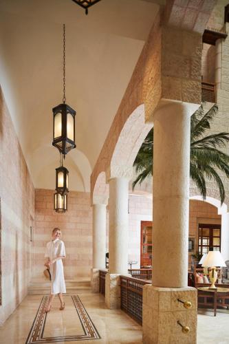 a woman walks through the lobby of a hotel at Mövenpick Resort Petra in Wadi Musa