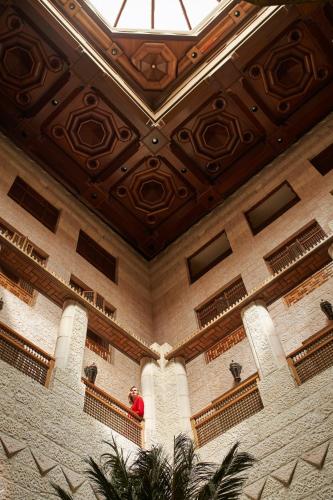 a man standing on a balcony in a building at Mövenpick Resort Petra in Wadi Musa