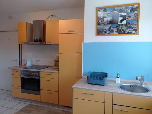 a kitchen with yellow cabinets and a sink at Artbox in Saarbrücken