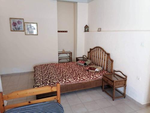 a small bedroom with a bed and a chair at Beautiful apartment ANAIS near the sea in Agia Triada