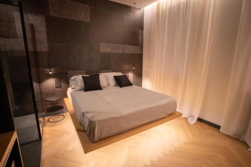 a bedroom with a white bed and a white curtain at S1 Luxury Suites and Rooms in Trieste