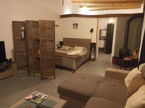 - un salon avec un canapé et un lit dans l'établissement La Cordonnerie de Las Places, à Campagne-dʼArmagnac
