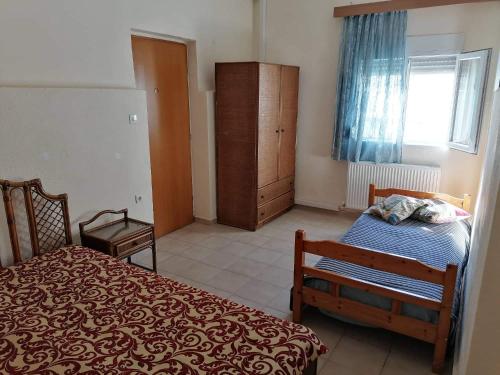 ein Schlafzimmer mit einem Bett, einem Schrank und einem Fenster in der Unterkunft Beautiful apartment ANAIS near the sea in Agía Triás