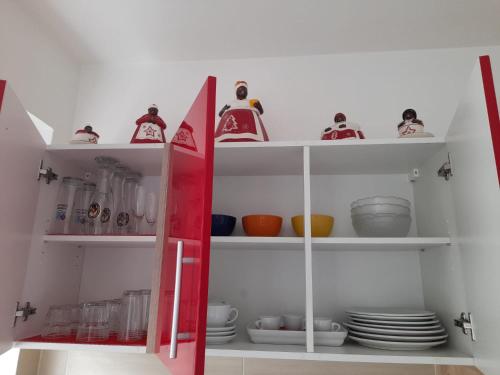 a red cabinet with plates and dishes in it at Ferienwohnung da Celia in Berchtesgaden