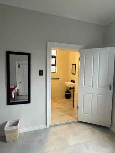 a room with a white door and a mirror at Villa Viva Cape Town in Cape Town