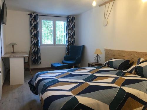 una camera con un letto, una sedia blu e una finestra di Au coeur de ville avec terrasse a Céret
