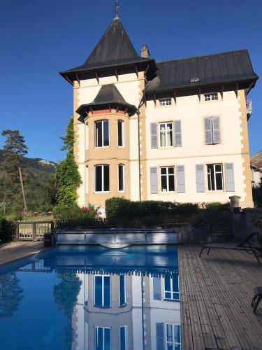un grand bâtiment avec une piscine devant dans l'établissement Villa Meyriem, à Mouthier-Haute-Pierre