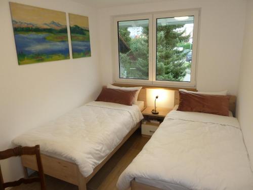 two beds in a room with a window at Ferienwohnung Blick ins Tal in Wangen im Allgäu