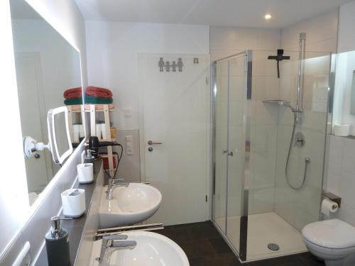a bathroom with two sinks and a shower and a toilet at Ferienwohnung Blick ins Tal in Wangen im Allgäu