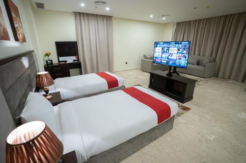 a hotel room with two beds and a flat screen tv at City View Hotel- Managed by Arabian Link International in Kuwait