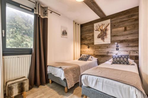 deux lits dans une chambre avec une fenêtre dans l'établissement Alta Rocca, à Chamonix-Mont-Blanc
