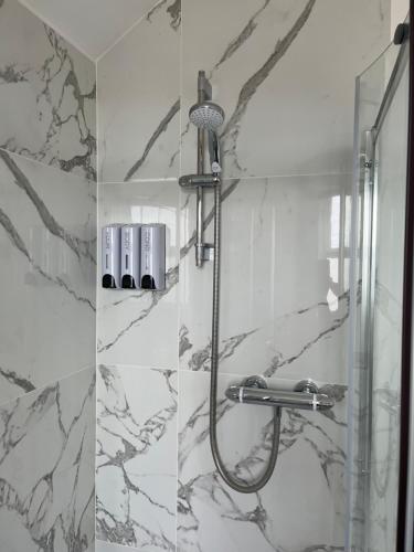 two pictures of a shower in a bathroom at Avocet House Hunstanton 250m from the sea in Hunstanton