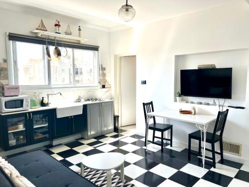 a kitchen with a black and white checkered floor at Shantell Luxury Apartment in Netanya