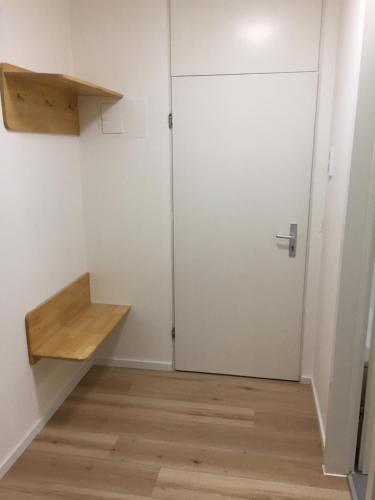 Pokój z białymi drzwiami i drewnianą podłogą w obiekcie City Center Apartment w Monachium