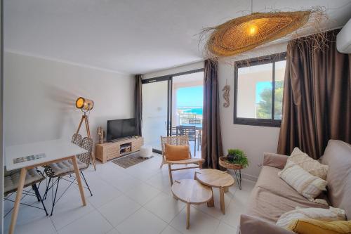un salon avec un canapé et une table dans l'établissement IMMOGROOM - Renovated - Sea view - Pool - Patio - Wifi - AC - Parking, à Cannes