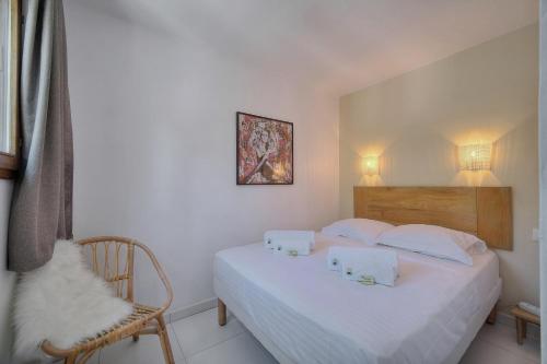 une chambre avec un lit blanc et une chaise dans l'établissement IMMOGROOM - Renovated - Sea view - Pool - Patio - Wifi - AC - Parking, à Cannes