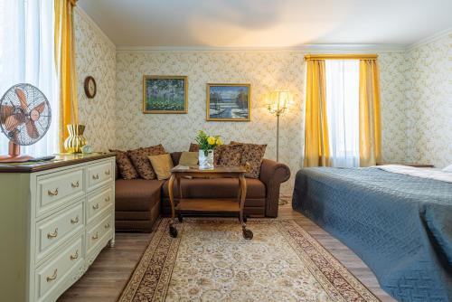 a bedroom with a bed and a couch and a table at Videviku Villa Apartments in Tallinn