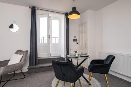 a living room with a table and two chairs at The Croston promenade balcony apartment- Morecambe central promenade, beach front and sea views in Morecambe