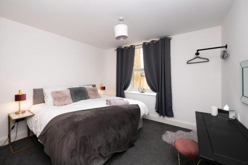 a bedroom with a bed and a window at The Croston balcony apartment- located on the central promenade, beach front and sea views in Morecambe