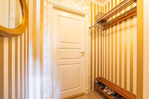 a hallway with a white door and yellow stripes at Videviku Villa Apartments in Tallinn