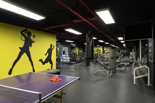 a gym with a ping pong table and a yellow wall at Mövenpick Resort Petra in Wadi Musa