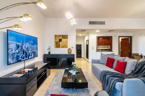 a living room with a couch and a tv at Luxe, spacious, 2BD Condo with Full kitchen, Marina View, Steps from JBR Beach, Tram & Marina by "La Buena Vida Holiday Homes" in Dubai