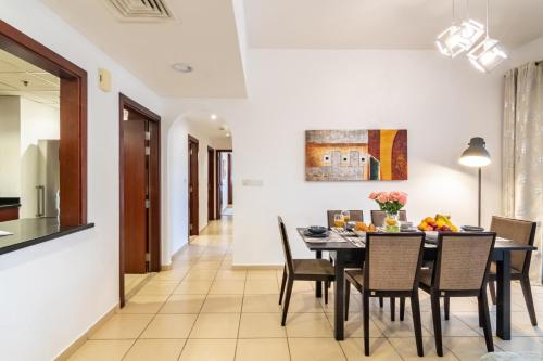 a dining room and kitchen with a table and chairs at Luxe, spacious, 2BD Condo with Full kitchen, Marina View, Steps from JBR Beach, Tram & Marina by "La Buena Vida Holiday Homes" in Dubai