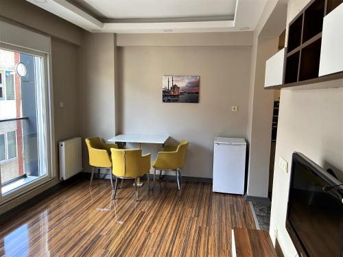 a dining room with a table and yellow chairs at Ninve Apartments – Istanbul Bakirköy in Istanbul