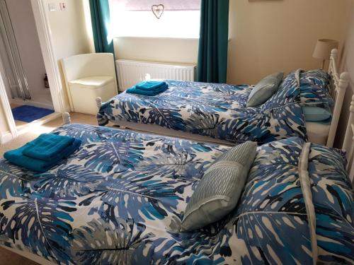 two beds in a bedroom with blue and white sheets at Bancroft Apartment in Durham