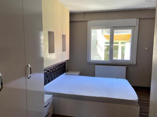a small bedroom with a bed and a window at Ninve Apartments – Istanbul Bakirköy in Istanbul