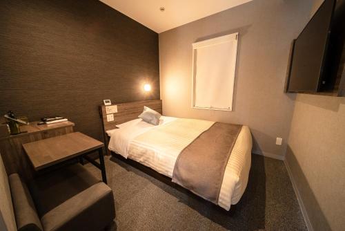a bedroom with a bed and a desk and a television at Super Hotel Premier Ikebukuro Natural Hot Spring in Tokyo