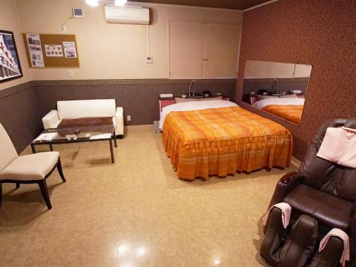 um quarto de hotel com duas camas e duas cadeiras em Mariage Leisure Hotel em Tsukuba