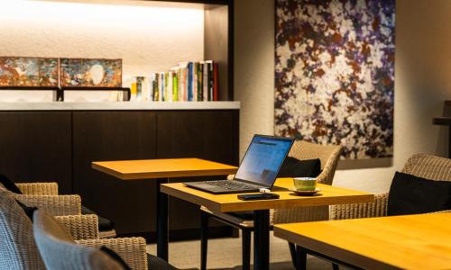 a laptop computer sitting on a table in a restaurant at HOTEL RINGS KYOTO in Kyoto