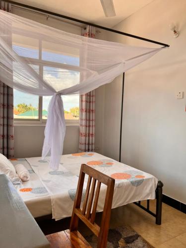 1 dormitorio con cama y ventana en Haika Home Lodge, en Dar es Salaam