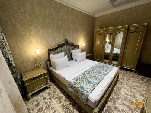 撒馬爾罕的住宿－Golden Samarkand Hotel，一间卧室配有一张大床和镜子