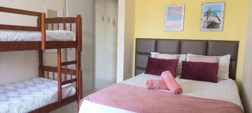 1 Schlafzimmer mit 2 Betten und 1 Etagenbett in der Unterkunft Conforto a 300m da Praia do Forte in Cabo Frio
