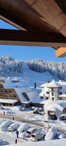 a ski resort with snow covered buildings and cars at Luxury Hotel Apartment - Jahorina in Jahorina