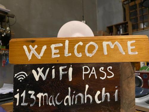 Una señal que dice bienvenida con moderación de mph pass en Hostel-John Cafe and Beer, en Da Lat