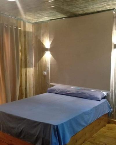 a bedroom with a bed with a blue sheet at New Moon Island Camp in Nuweiba