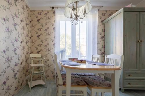 a dining room with a table and chairs and a window at Videviku Villa Apartments in Tallinn