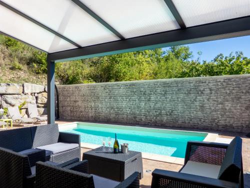 an outdoor patio with a swimming pool and a pergola at Impasse des Faysses in Ruoms