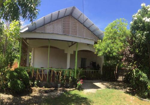 ein kleines Haus mit einer Veranda im Hof in der Unterkunft La Villa Alta in Siquijor