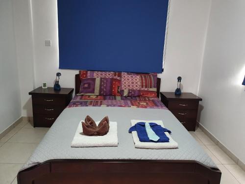 a bedroom with a bed with towels and shoes on it at HomeSweetHome in Paphos