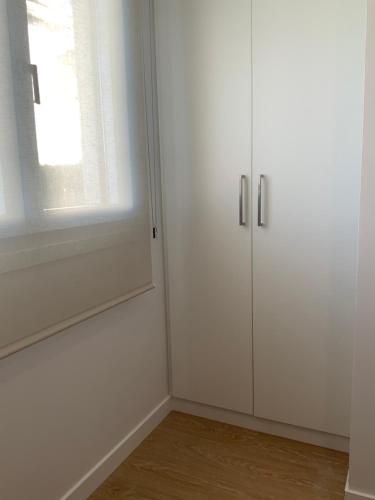 a room with white cabinets and a window at SUPER CHOLLO SEPTIEMBRE Apartamento a pie de playa BLUE nuevo, tu mascota es bienvenida in Noja