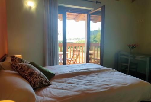 a bedroom with a bed with a view of a balcony at Le Acacie in Torreano